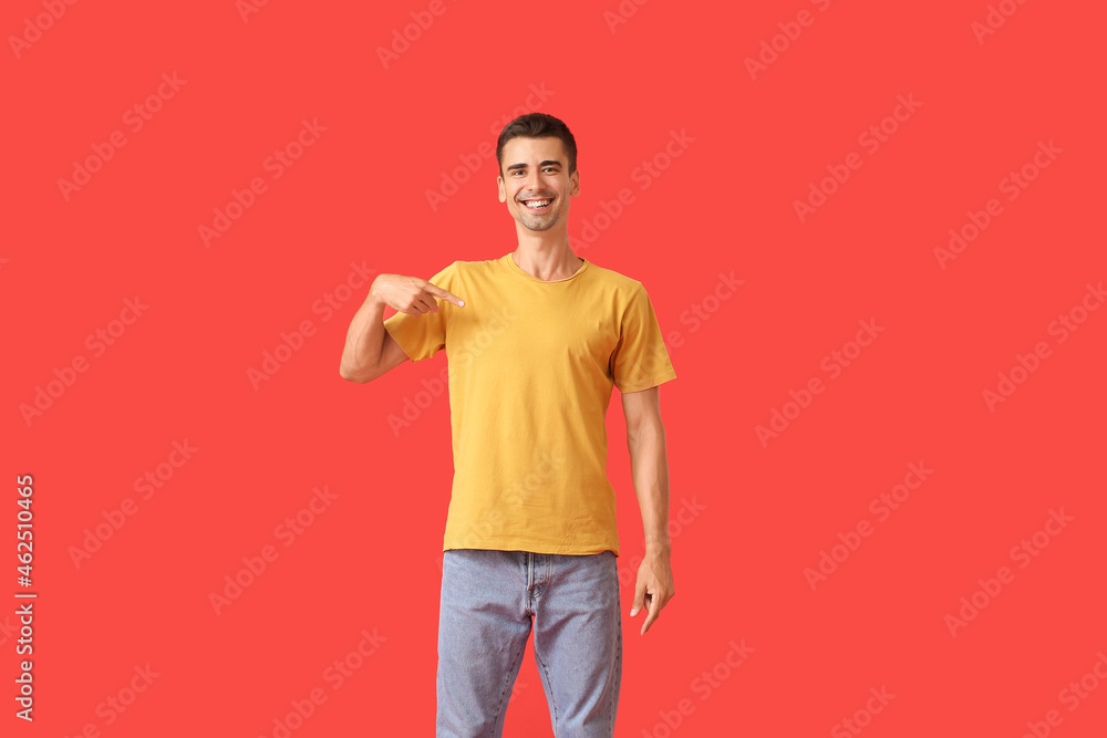 Handsome young man in stylish t-shirt on color background