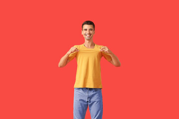 Wall Mural - Handsome young man in stylish t-shirt on color background