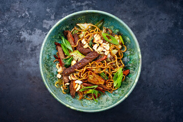 Modern style pad Thai beef with angus roast beef slices, noodles and vegetable served as top view in a Nordic design bowl with copy space