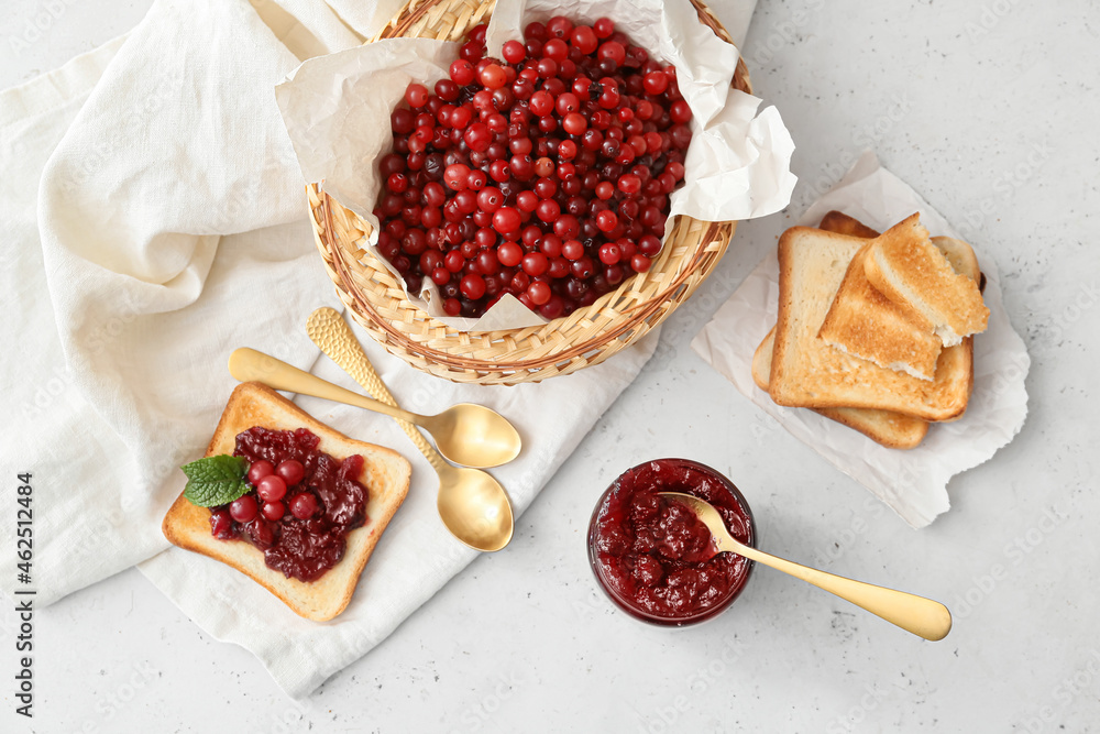 Composition with tasty cranberry jam, berries and toasts on light background