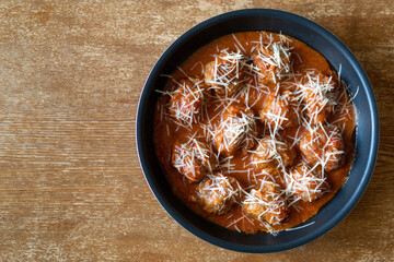 Homemade meatballs with tomato sauce and cheese. Top view on wooden table with copy space.