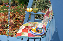 Fall Harvest Decor On Outside Swing In Backyard Garden Setting For Afternoon Relaxation. Background, Copy Space.