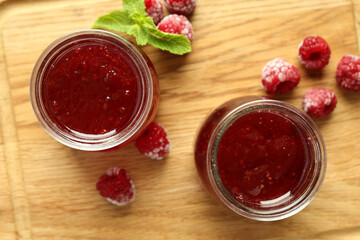 Wall Mural - Glass jars of raspberry jam with ingredients on wooden board