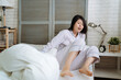 © PR Image Factory - Young frustrated and stressed asian chinese woman late for work. shocked girl in striped pajamas waking up and jump out from bed. worried female oversleep in the morning on first day of new job.