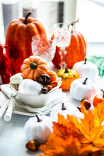 Autumnal Thanksgiving Place Setting On A Table With Pumpkin Ornaments And Leaf Decorations