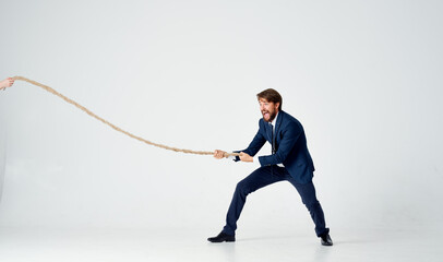 Poster - a man in a suit pulls the rope emotion work office