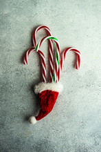 Three Red And White Candy Canes And Red, White And Green Candy Cane In A Santa Hat