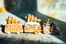 Three Car Shaped Gingerbread Cookies With Christmas Trees On A Table