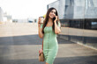 Young girl with coffee to go holding smartphone. Beautiful woman talking to the phone while enjoying in fresh coffee
