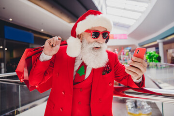 Canvas Print - Photo of santa hold phone carry present bags make social media post wear sunglass hat red tux in supermarket mall center