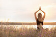 © New Africa - Young woman meditating near river on sunny day, back view. Space for text