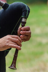 Hands of a musician playing a bagpipe from Galicia, Spain.