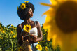 © oneinchpunch - Beautiful afro american woman in a sunflowers field
