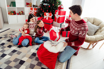 Sticker - Photo of excited sweet couple two kids dressed new year pullovers smiling getting gifts indoors house home room