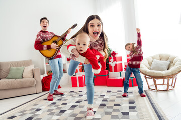 Sticker - Photo of positive ecxited couple two kids dressed new year pullovers smiling playing guitar dancing indoors house home room