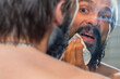 © Никита Федонников - A man with a beard got dirty with blue paint and is now wiping his beard with a napkin