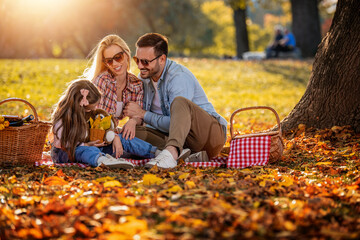 Wall Mural - Joyful family picnicking in the park