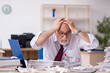 © Elnur - Old male employee unhappy with excessive work in the office