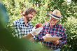 © Anna Bizon/Westend61 - Fruit growers checking quality of apples in their orchard