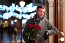 Portrait Of Waiting Man With Bunch Of Red Roses Checking The Time