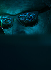 Cyber Crime, reflection in spectacles of virus hacking a computer, close up of face