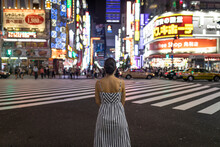 Young Woman Contemplating At Night, People Crossing Shinjuku Street, Tokio, Japan