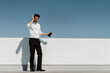 © VITTA GALLERY/Westend61 - Happy businessman listening music with headphones and smartphone on roof terrace