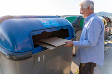 Senior man recycling cardboard in paper bank