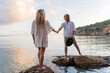 © VITTA GALLERY/Westend61 - Young couple standing on rocks in front of the sea holding hands, Ibiza, Balearic Islands, Spain