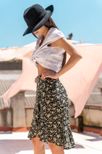 Fashionable Young Woman Wearing Hat, Wrap-around Blouse And Skirt With Floral Design