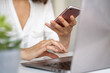 © VITTA GALLERY/Westend61 - Close-up of woman using cell phone and laptop at desk
