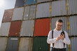 © Hernandez and Sorokina/Westend61 - Manager in front of cargo containers on industrial site using cell phone