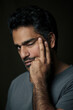 © Alberto Bogo/Westend61 - Portrait of an Indian man, pulling one eye closed