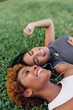 © Mattia Pelizzari/Westend61 - Portrait of two happy female friends relaxing in a park listening to music