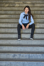 Portrait Of Fashionable Young Businesswoman Sitting On Stairs