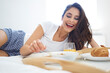 © Bartek Szewczyk/Westend61 - Young woman enjoying breakfast in bed
