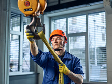 Industrial Worker Fixing Hoist Sling On Indoor Crane