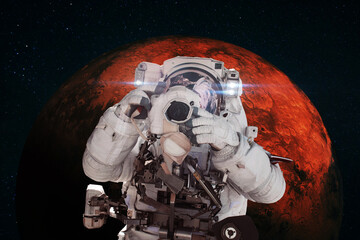 Wall Mural - astronaut photographer with a camera taking pictures against the background of the red planet mars. 