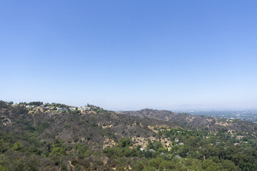 Sticker - View of Hollywood Hills seen from Mulholland Drive on a sunny summer day. Houses and trees