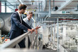 © Daniel Ingold/Westend61 - Two businessmen talking in a modern factory