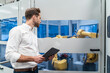 © Daniel Ingold/Westend61 - Businessman with tablet looking at robot in a modern factory