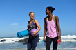 © Eyecatcher.pro/Westend61 - Two happy women with fitness equipment walking on the beach