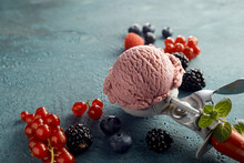 Raspberry ice cream on scoop and fresh fruits