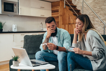 Wall Mural - Couple using a laptop and a credit card for an online shopping at home