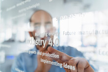 Businessman In Front Of Glass Pane Pointing On Words, Industry 4.0