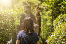 Woman Looking At Buddha Statue At A Sunny Day