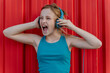 © Eloisa Ramos/Westend61 - Girl with headphones in front of red wall