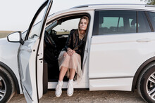 Blond Woman With Closed Eyes, Sitting In White Car