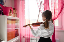 Girl Playing Violin At The Window At Home