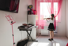 Girl Playing Violin At The Window At Home